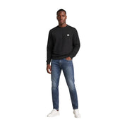 Calvin Klein Jeans Sweat-shirt noir à manches longues et col rond pour homme, en coton, avec un petit logo blanc sur la poitrine gauche.