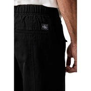 Calvin Klein Jeans Pantalon noir en coton pour homme, à cordon de serrage, au design minimaliste et élégant, avec un discret logo sur la ceinture.