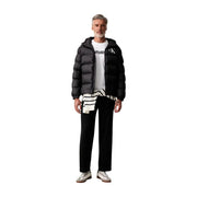 Doudoune noire matelassée à capuche avec logo Calvin Klein blanc sur la poitrine, pour homme, avec pantalon en coton noir.