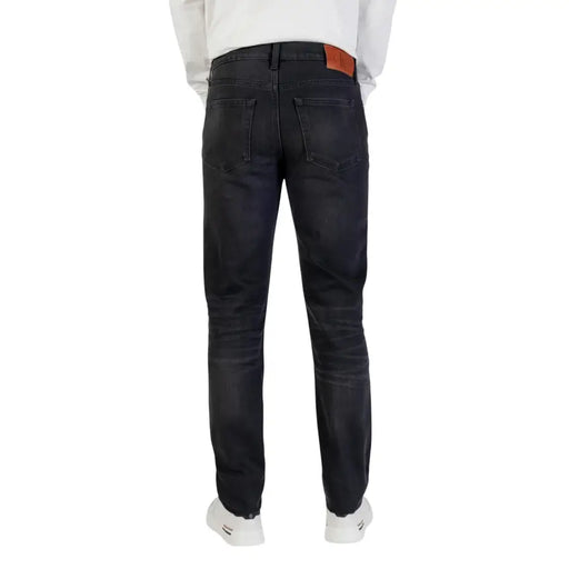 Coupe slim délavée foncée Calvin Klein Jean en coton pour homme avec fermeture éclair noire et étiquette de marque en cuir marron à la ceinture