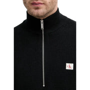 Calvin Klein Jeans Pull en maille de coton noir pour homme, avec demi-zip argenté et écusson logo blanc sur la poitrine