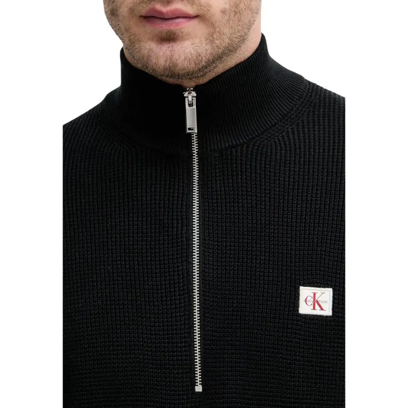 Calvin Klein Jeans Pull en maille de coton noir pour homme, avec demi-zip argenté et écusson logo blanc sur la poitrine