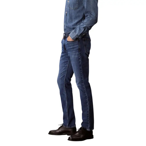 Jean Calvin Klein pour homme, en denim de coton bleu foncé, référence LV04RB735G, coupe droite classique et surpiqûres apparentes.