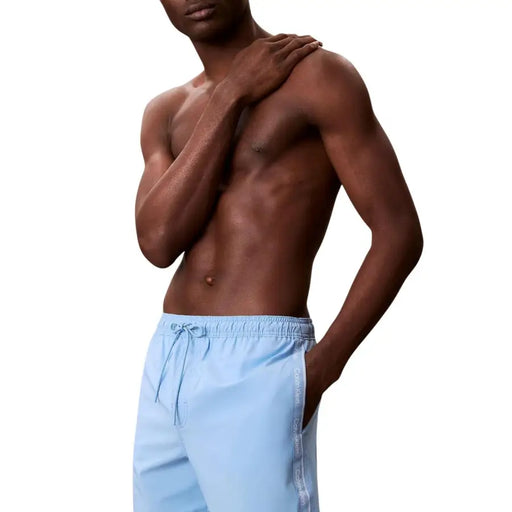 Maillot de bain homme Calvin Klein Jeans bleu clair, short de bain en polyester avec ceinture à cordon et logo vertical.