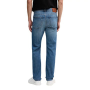 Vue arrière d'un jean Calvin Klein pour homme, en denim de coton bleu, coupe droite, avec un écusson de la marque en cuir marron.