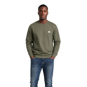 Calvin Klein Jeans Sweat-shirt vert en coton pour homme, col rond, avec un petit logo blanc sur la poitrine gauche.