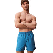 Calvin Klein Jeans Short de bain homme bleu clair en polyester, avec slip bleu vif et ceinture à cordon.