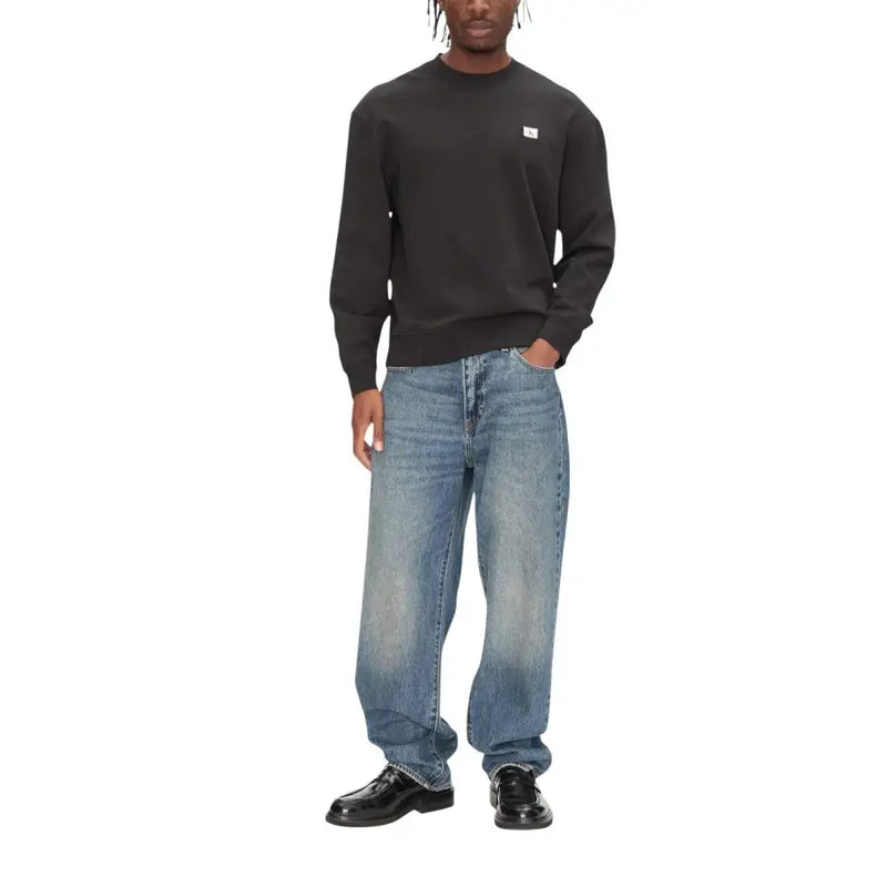 Calvin Klein Jeans Sweat-shirt noir en coton à col rond et manches longues pour homme, orné d'un petit logo blanc sur la poitrine.
