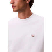 Calvin Klein Jeans Sweat-shirt homme en coton blanc à col rond avec petit logo rouge et noir sur la poitrine gauche.