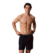 Black Calvin Klein Jeans men swim trunks with white logo band and drawstring waistband for swimwear use