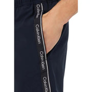 Dark navy calvin klein jeans men swimwear track pants with black and white branded side stripe for casual wear