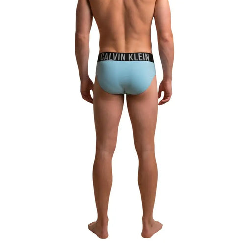 Light blue calvin klein jeans men swimwear briefs with black waistband and white brand lettering