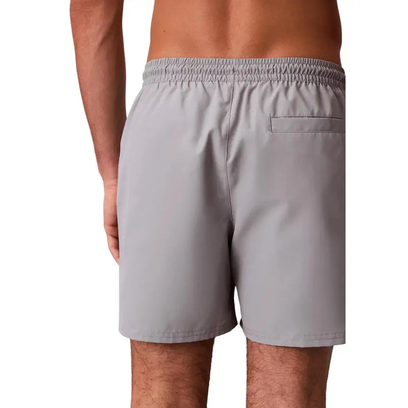 Back side of gray Calvin Klein Jeans men swimwear shorts with elastic waistband and single back pocket