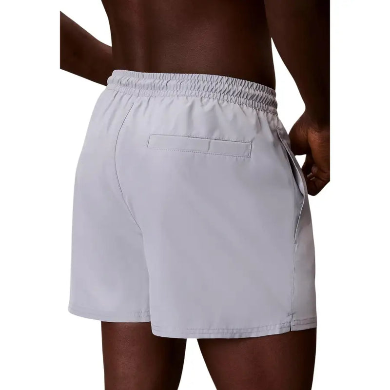 Calvin Klein Jeans men swimwear light gray lightweight swim trunks with elastic waistband and single back pocket view