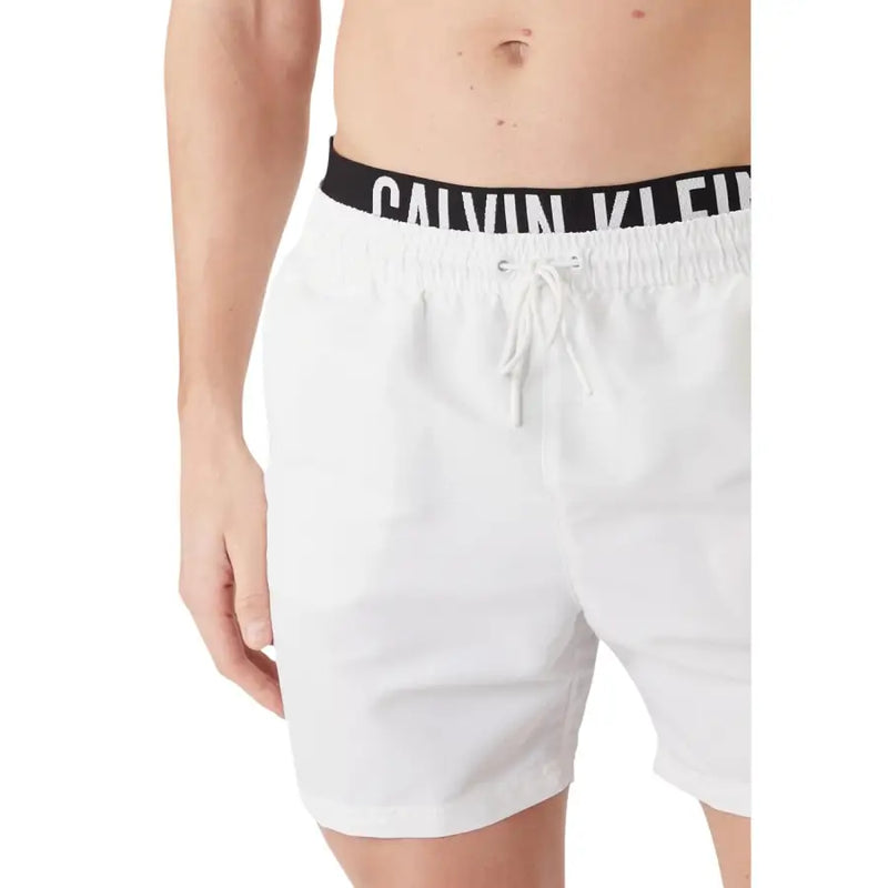 White Calvin Klein Jeans men swimwear trunks with black elastic waistband featuring white Calvin Klein logo