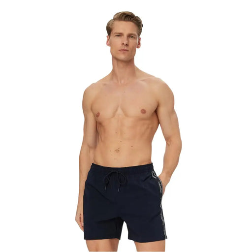 Navy blue Calvin Klein Jeans men swimwear swim trunks with white logo stripe along the side for casual beachwear