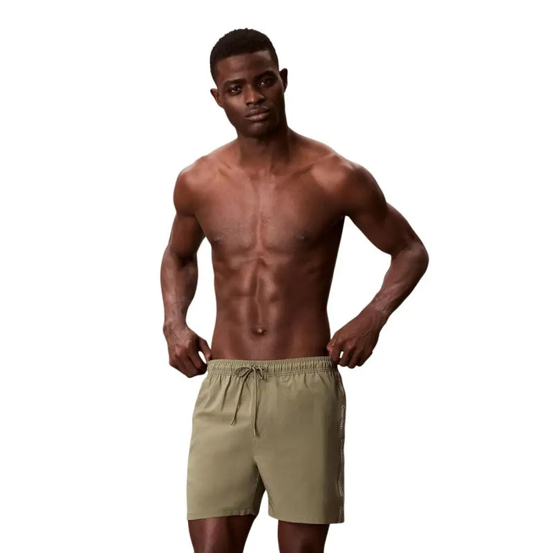 Calvin Klein Jeans men swimwear olive green athletic shorts with drawstring waistband and subtle side panel detailing