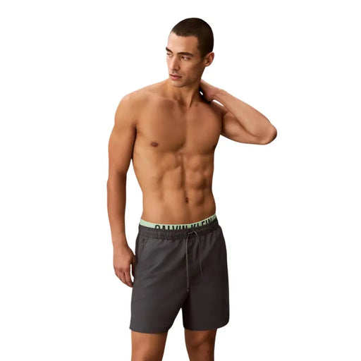 Dark gray calvin klein jeans men swimwear shorts with a light green logo waistband for swimwear use