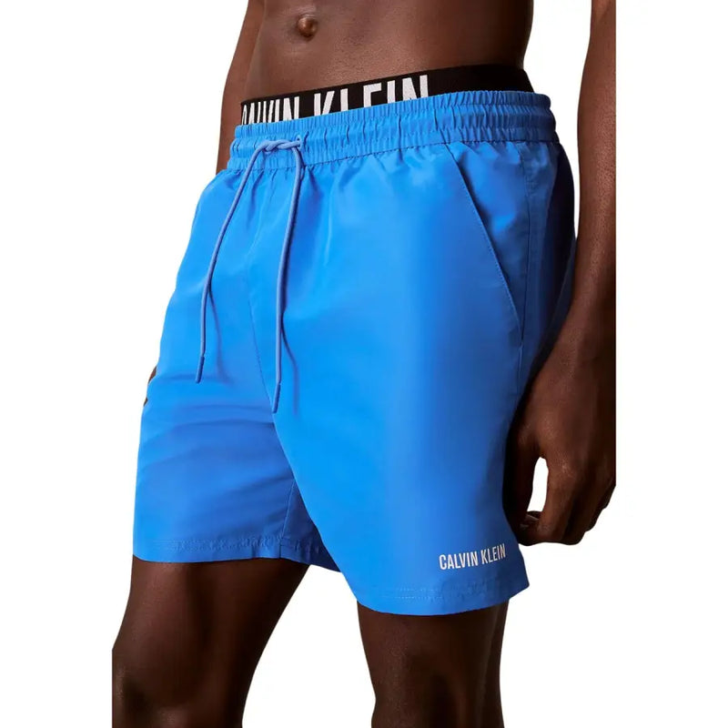 Calvin Klein Jeans men swimwear bright blue swim trunks with black waistband white lettering and matching drawstrings