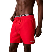 Bright red Calvin Klein Jeans men swimwear trunks with black waistband and white branding featuring matching drawstrings