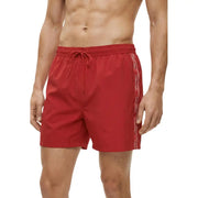 Red Calvin Klein Jeans men swimwear swim trunks featuring a white logo stripe along the side
