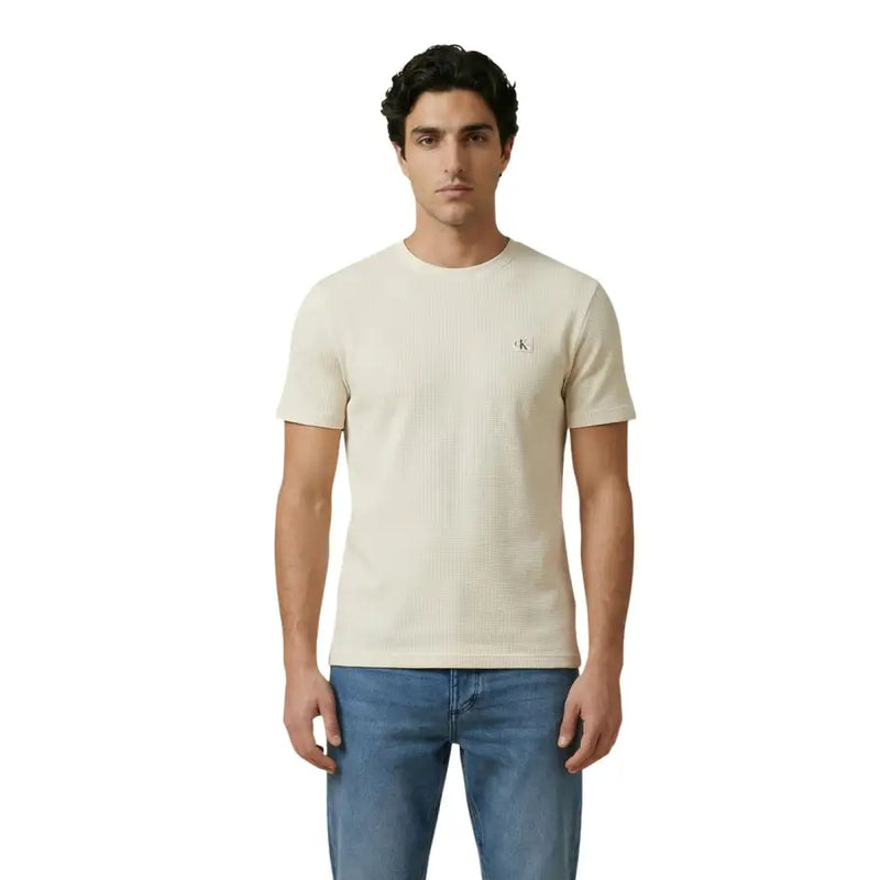 couleur crème Calvin Klein Jeans hommes t-shirt avec un tissage texturé subtil et un petit logo brodé sur la poitrine gauche