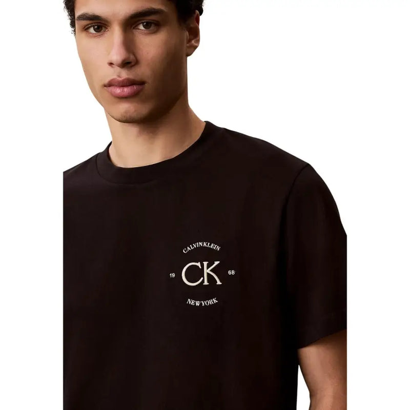 Noir Calvin Klein Jeans coton pour hommes t-shirt T-shirt à col rond, taille S, avec logo CK brodé crème et inscription « 1968 New York ».