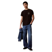 Calvin Klein Jeans T-shirt noir en coton pour homme avec logo circulaire blanc sur la poitrine et col rond.