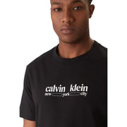 Black cotton calvin klein jeans men t shirt with white calvin klein new york city logo on the chest and short sleeves