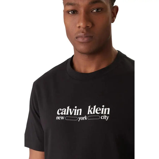 Black cotton calvin klein jeans men t shirt with white calvin klein new york city logo on the chest and short sleeves