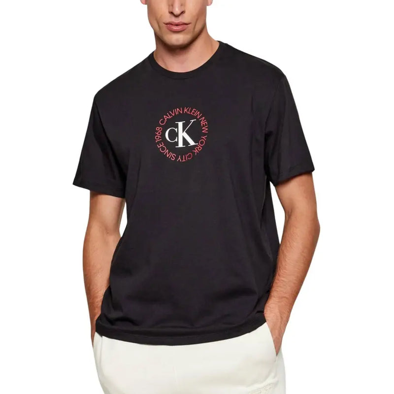 Noir Calvin Klein Jeans hommes t-shirt avec le logo CK circulaire blanc et rose sur le devant