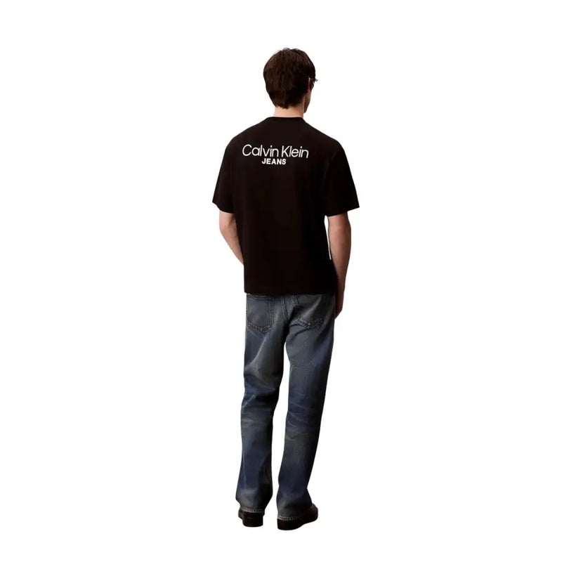 Vue arrière d'un t-shirt Calvin Klein Jeans pour homme, en coton noir avec un logo blanc imprimé au dos.