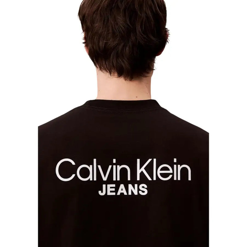 Vue arrière d'un t-shirt Calvin Klein Jeans pour homme, en coton noir avec inscription blanche en gras sur le dos