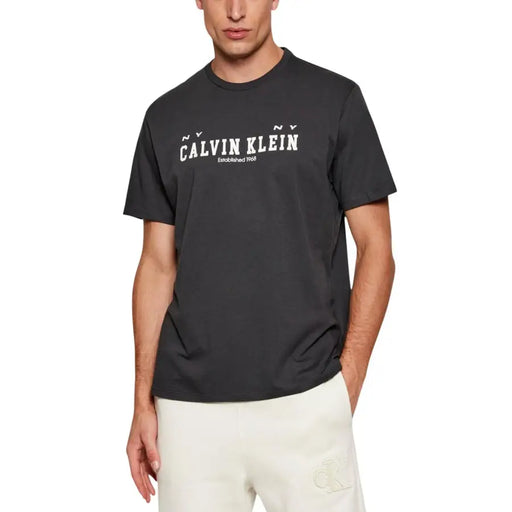 Noir Calvin Klein Jeans hommes t-shirt avec du blanc ny Calvin Klein logo créé en 1969 sur la poitrine
