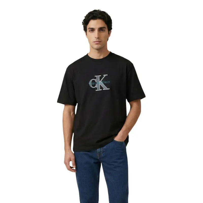 Noir Calvin Klein Jeans hommes t-shirt avec un logo CK brodé bien visible en turquoise et des détails argentés