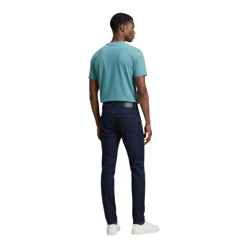 Jeans Calvin Klein pour hommes t-shirt associé à un jean slim bleu foncé orné de surpiqûres discrètes.