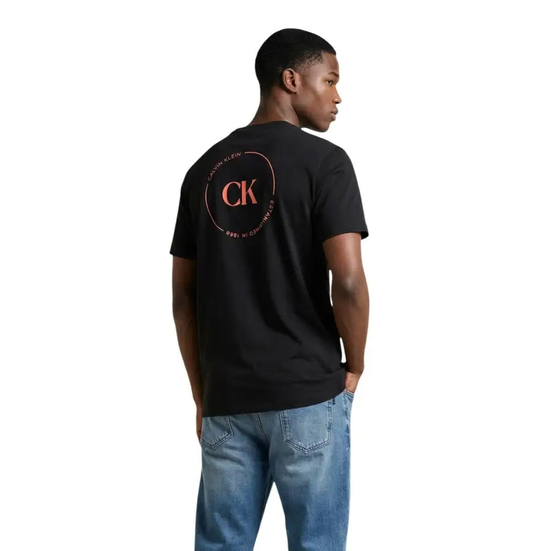 Noir Calvin Klein Jeans hommes t-shirt orné d'un logo CK rose circulaire avec les initiales sur le devant