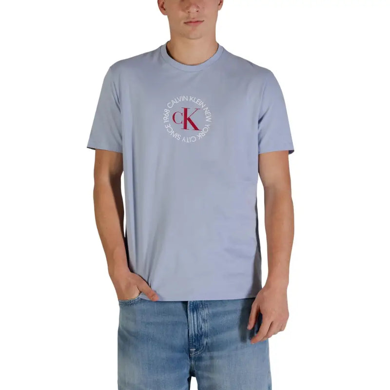 bleu clair Calvin Klein Jeans hommes t-shirt orné d'un logo CK circulaire rouge et blanc sur le devant