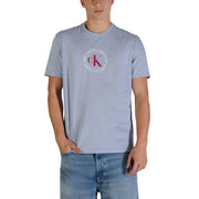 Light blue Calvin Klein Jeans men t-shirt featuring a circular red and white ck logo on the front
