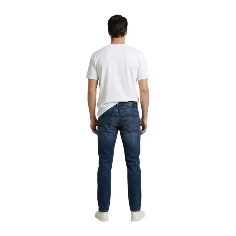T-shirt Calvin Klein Jeans pour homme, en coton blanc imprimé, associé à un jean slim bleu foncé à cinq poches classiques.