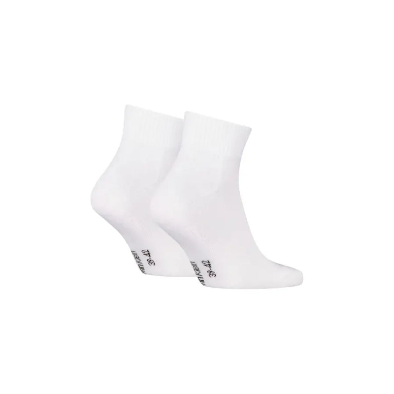 Une paire de blancs Calvin Klein Jeans Chaussettes pour homme, style minimaliste, avec inscription noire au talon.