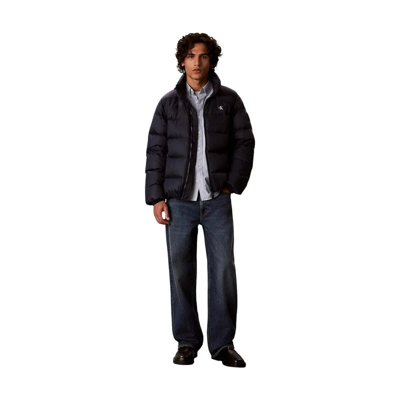 Calvin Klein Jeans Doudoune noire pour homme, matelassée, avec logo discret sur la poitrine gauche (vue de face).