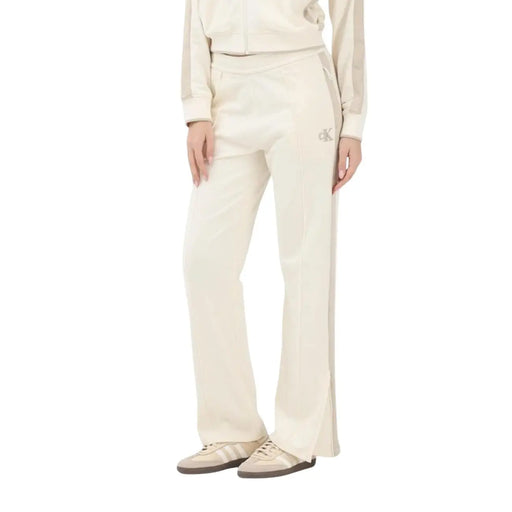 Calvin Klein Jeans Pantalon en coton beige pour femme, comprenant un pantalon de survêtement couleur crème avec fente latérale et logo brodé