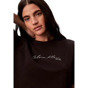 Col rond en coton noir Calvin Klein Jeans T-shirt femme avec logo blanc en écriture cursive et détail est sur le devant