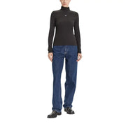 Woman wearing Calvin Klein Jeans black long turtleneck knitwear with blue jeans and black boots