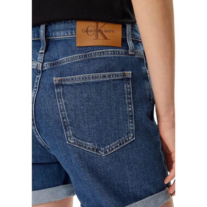 Dark blue cotton denim shorts for women with rolled cuffs and a brown leather calvin klein patch on the back waistband