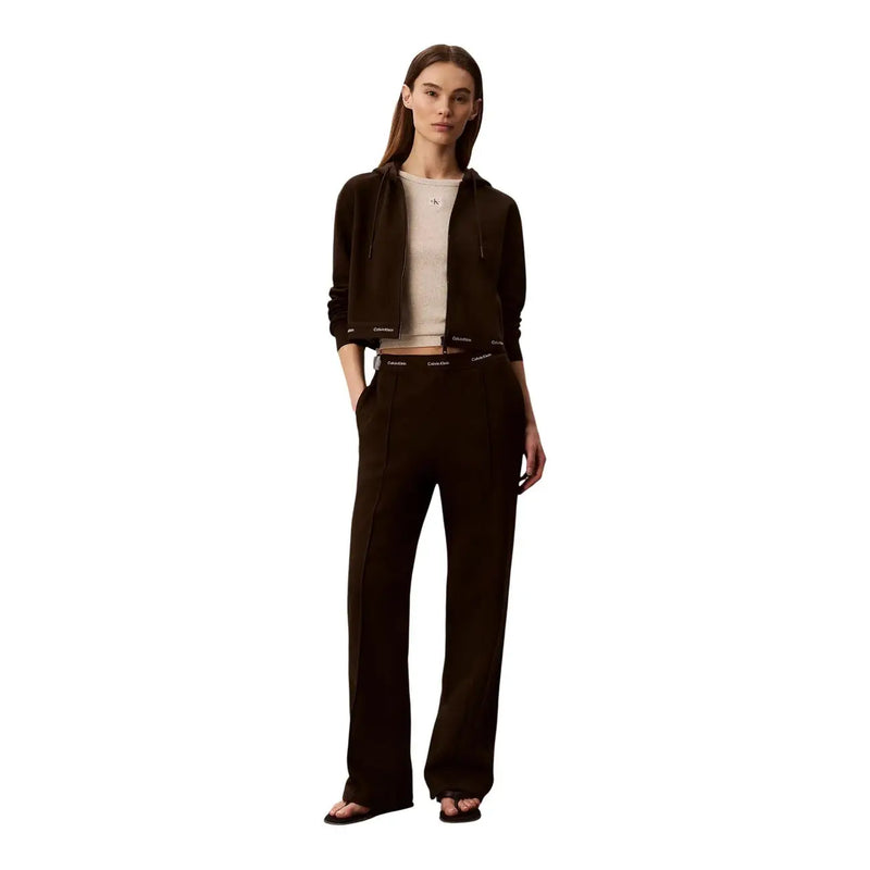 Sweat à capuche noir Calvin Klein avec poignets et taille côtelés et logo discret, porté avec un pantalon en coton marron