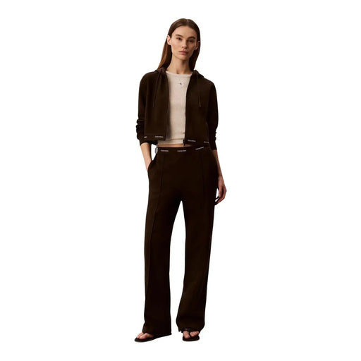 Sweat à capuche noir Calvin Klein avec poignets et taille côtelés et logo discret, porté avec un pantalon en coton marron
