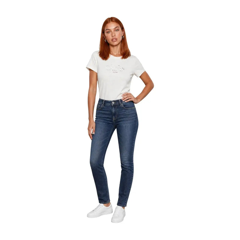 Jean skinny taille haute bleu foncé associé à un t-shirt blanc en coton à col rond de la collection femme de Calvin Klein Jeans.