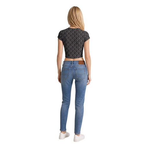 Un jean skinny bleu clair à passants de ceinture en cuir marron, porté avec un t-shirt gris en coton à col rond Calvin Klein Jeans pour femme.